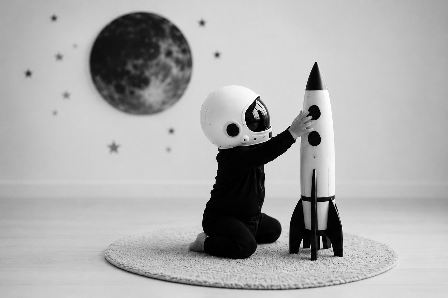 ECLIPSE short sleeved baby romper — lifestyle, child in astronaut helmet with rocket, monochrome